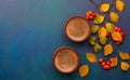 Two cups of black coffee and branches of autumn leaves Spiraea Vanhouttei with small red rowan`s fruits on a dark blue-green pai Royalty Free Stock Photo