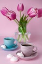 A two cups of black coffee and a vase with bouquet pink tulip on the pink background. Close-up Royalty Free Stock Photo