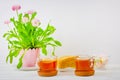 Two cups of black tea, marshmallows, cake slices and a pink flower pot on the table Royalty Free Stock Photo