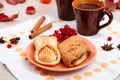 Two cups of brown clay with tea are on a white linen napkin. Butter cookies with fruit jam and cake with cottage cheese are on a r Royalty Free Stock Photo