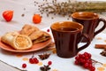 Two cups of brown clay with tea are on a white linen napkin. Butter cookies with fruit jam and cake with cottage cheese are on a r Royalty Free Stock Photo