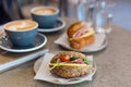 Two cups of cappuccino with latte art, sandwich and croissant on marble background. Concept of easy breakfast. Gray Royalty Free Stock Photo