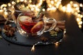 Two cups of Christmas mulled wine or gluhwein with spices and lemon slices on dark wooden background with defocused lights. Royalty Free Stock Photo