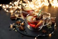 Two cups of Christmas mulled wine or gluhwein with spices and lemon slices on dark wooden background with defocused lights. Royalty Free Stock Photo
