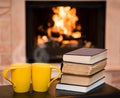 Two cups of coffee with books on the background of the fireplace Royalty Free Stock Photo