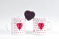 Two cups of coffee and candy in the form of heart on a white background - Breakfast for lovers.