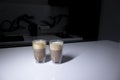 Two cups of coffee in double-botoom glass on white table in gray kitchen