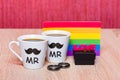 Two cups of coffee, gay flag and a black gift box with marriage ring