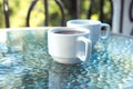 Two cups of coffee on a glass table on an open terrace Royalty Free Stock Photo