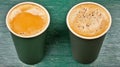 Two cups of coffee on a green table, cozy coffee break scene two Royalty Free Stock Photo