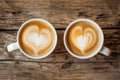 Two cups of coffee with heart latte art, date concept. Valentine\'s day or coffee lovers. Couple of cappuccino cups on wooden Royalty Free Stock Photo