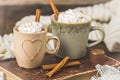 Two cups of coffee or hot chocolate with cream and cinnamon on an old book on wooden background Royalty Free Stock Photo