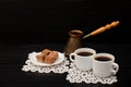 Two cups of coffee on the lace napkins, pots and chocolate turkish dessert on a black background Royalty Free Stock Photo