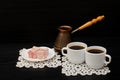 Two cups of coffee on the lace napkins, pots and turkish dessert on a black background Royalty Free Stock Photo