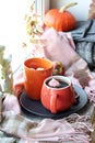Two cups of coffee, meringues, pumpkins, apples, leaves, plaid on the background of the window