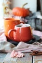 Two cups of coffee, meringues, pumpkins, apples, leaves, plaid on the background of the window