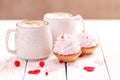 Two cups coffee and pink cream cupcakes on white wooden background. Concept Valentine`s Day, birthday, Wedding day Royalty Free Stock Photo