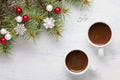 Two cups of coffee and spruce branch with Christmas decorations on old wooden shabby background