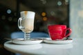 Two cups of coffee stand on a table in a coffee shop, latte and cappuccino, coffee date