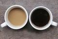 Two cups of coffee on the table. Couple cup of white coffee and black coffee on rustic wooden table background Royalty Free Stock Photo