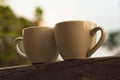 Two cups of coffee on wooden balcony on the background of sunset with beautiful bokeh lights Royalty Free Stock Photo