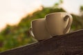 Two cups of coffee on wooden balcony on the background of sunset with beautiful bokeh lights Royalty Free Stock Photo