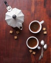 Two cups of espresso with pieces of cane sugar and Italian coffee maker. Royalty Free Stock Photo