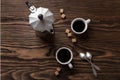 Two cups of espresso with pieces of cane sugar and Italian coffee maker on table. Royalty Free Stock Photo