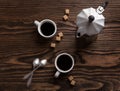Two cups of espresso with pieces of cane sugar and Italian coffee maker. Royalty Free Stock Photo