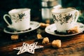 Two cups of espresso with pieces of cane sugar and Italian coffee maker on wooden table. Royalty Free Stock Photo