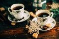 Two cups of espresso with pieces of cane sugar and Italian coffee maker on wooden table. Royalty Free Stock Photo
