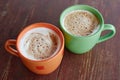 Two cups of fragrant cappuccino on a wooden roofing paper. Airy milk foam of a hot drink. Coffee drink with milk Royalty Free Stock Photo