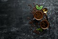 Two cups of fragrant coffee and coffee beans on a black stone background.