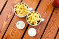 Two cups of french fries, two creamy sauces and lemonade on brown red boards wooden table. Fastfood, potato, flat lay, top view