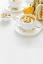 Two cups with fresh pumpkin cream soup decorated cream, seeds and crackers