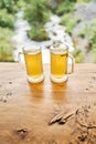 Two cups of ginger root tea with lemon, honey and mint on a wooden table and High-mountain river in the background. Walk Royalty Free Stock Photo