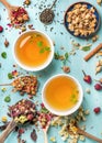 Two cups of healthy herbal tea with mint, cinnamon, dried rose and camomile flowers in spoons over blue background Royalty Free Stock Photo