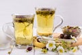 Two cups of herbal tea with rosehip , chamomile, herbs on white wooden table