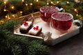 Two cups with hot Christmas spicy drink with cranberry and cakes