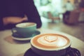 Two cups of hot coffee at cafe, one with heart shape latte art Royalty Free Stock Photo