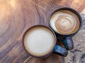 Two cups of hot coffee cappuccino on wood texture background in Royalty Free Stock Photo