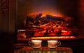 Two cups of hot drink near fireplace. Royalty Free Stock Photo