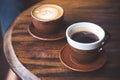 Two cups of hot latte coffee and black coffee on vintage wooden table in cafe Royalty Free Stock Photo