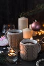 Two cups in knitted mittens of fresh hot cocoa or chocolate on wooden christmas background, dark photo Royalty Free Stock Photo