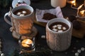 Two cups in knitted mittens of fresh hot cocoa or chocolate on wooden christmas background, dark photo Royalty Free Stock Photo