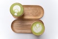Two Cups of Macha Latte on a Wooden Plate Isolated.