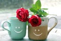 Two Cups of morning coffee or tea and roses. Couple cup with happy smiles and red rose on the table. New life valentine concept. Royalty Free Stock Photo