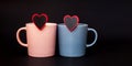 Two cups pink and gray color for coffee, stand on a black background. Coffee day. Valentine\'s Day. Close- Royalty Free Stock Photo