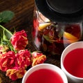 Two cups of red tea, bouquet of roses flowers and clear teapot with herbal and lemon drink. Romantic date. Tea for two