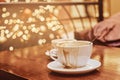 Two cups with spilled coffee on the wooden table in a coffee shop, blur background with bokeh effect Royalty Free Stock Photo